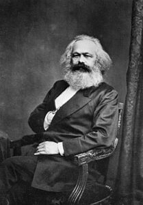 Karl Marx seated.